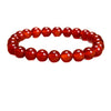 Close up view of a red faceted bead bracelet on a white background