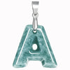 Polished blue-green jade letter pendant hanging on a silver-tone chain against a white background