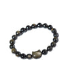 A wrist wearing a beaded golden obsidian bracelet with a cat charm