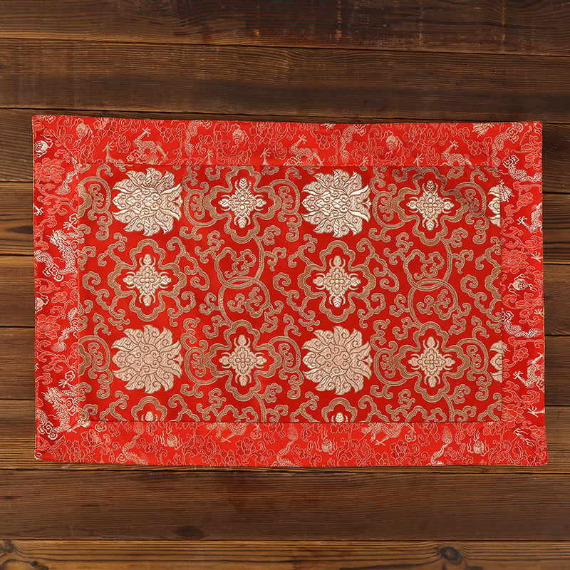 Close up of red, yellow and blue brocade fabric with dragon and lotus patterns