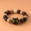 Close up of a wood bead bracelet with a black cat face charm