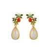 Gold-tone butterfly drop earrings with white faux jade and pearl accents resting on a book