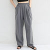 Model wearing gray high-waisted wide-leg trousers with hands in pockets