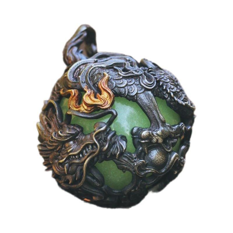 Close up of a copper dragon pendant wrapped around a green glow in the dark bead