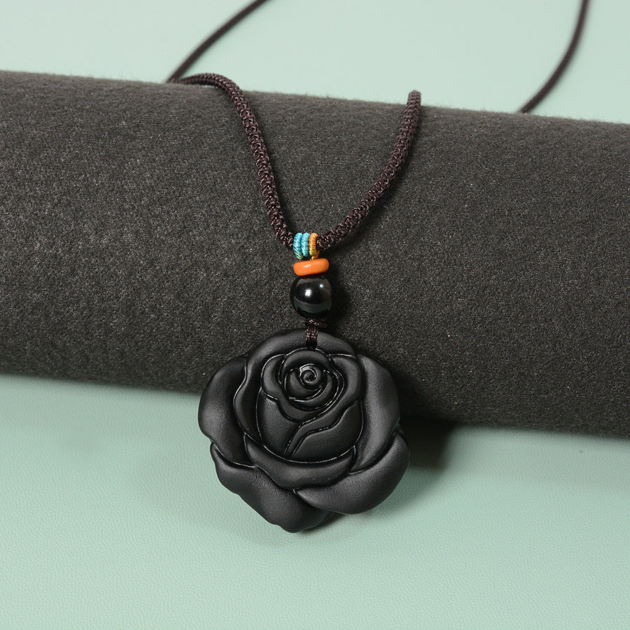 Matte black obsidian rose pendant on a dark brown cord