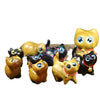 Collection of small wooden cat figurines in various wood colors sitting on a table.