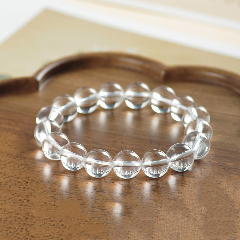 Close up of a clear crystal bead bracelet on a wooden tray
