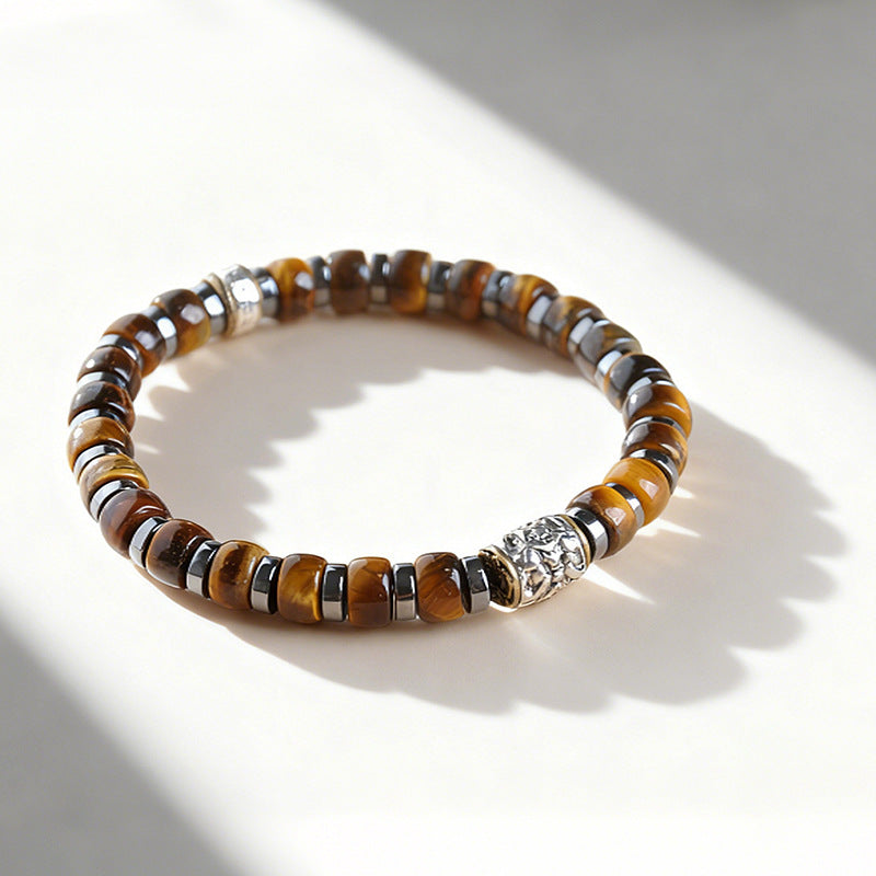 Close up of a tiger eye bead bracelet with a silver-tone lion charm on a wrist