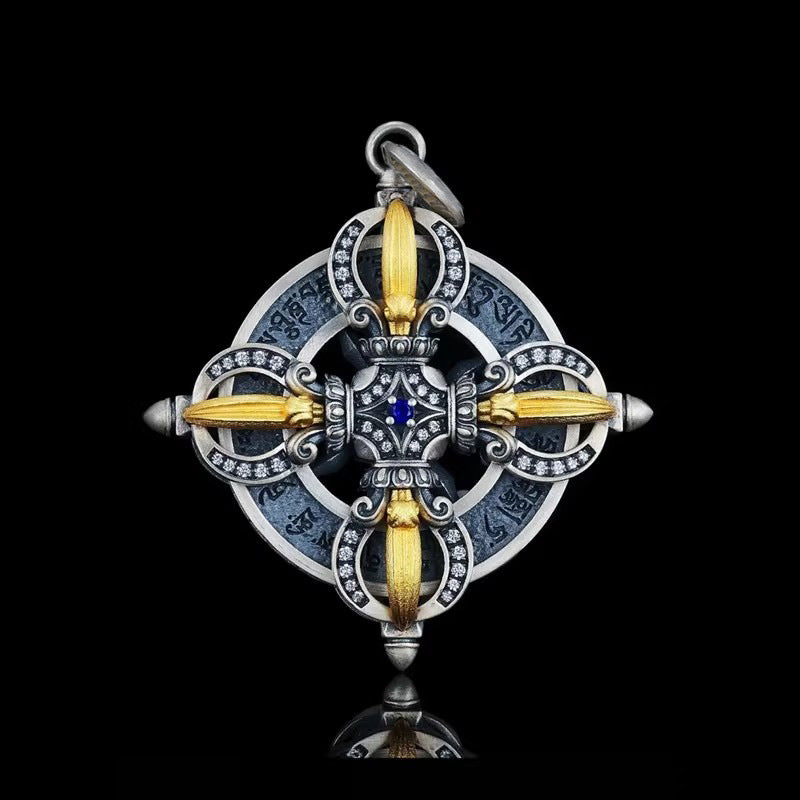 Close up of a silver tone vajra pendant with blue center stone on black background