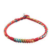 Close-up view of a handmade five color thread protection bracelet with red base and multicolored woven accents