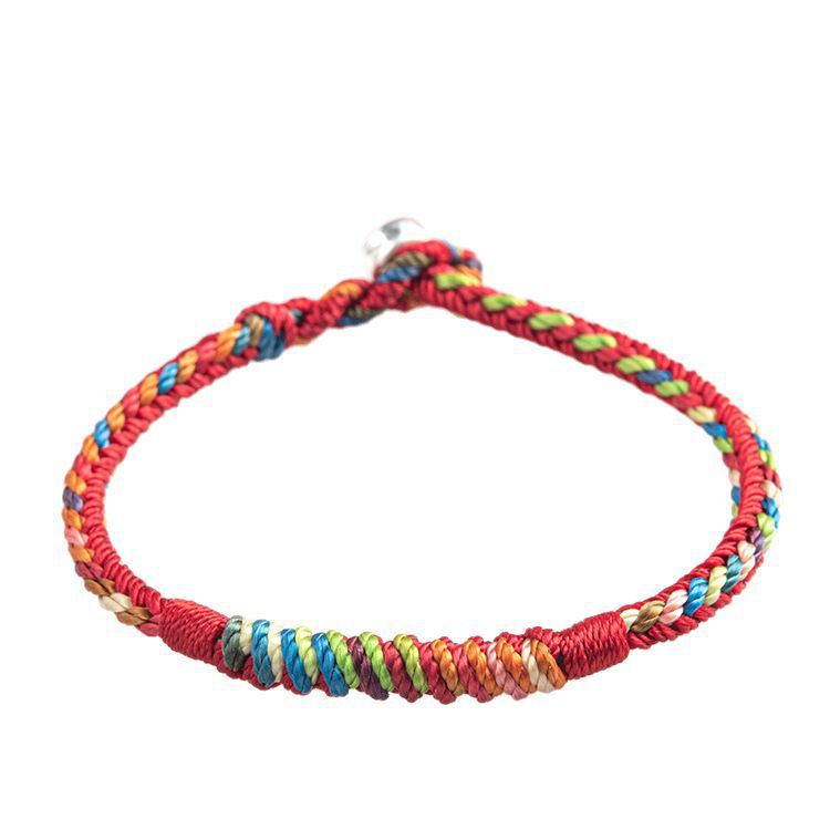 Close-up view of a handmade five color thread protection bracelet with red base and multicolored woven accents