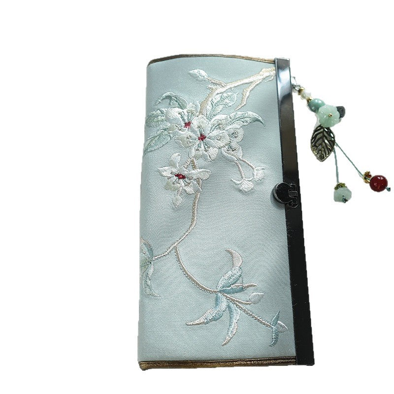 Light blue suede wallet with white floral embroidery and a beaded dangle charm