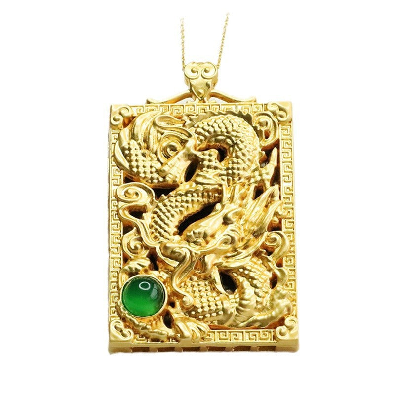 Rectangular gold-tone pendant with a raised dragon design and a green gemstone