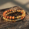 Double wrap bracelet with brown bodhi seeds and yellow crystal beads on a wooden surface