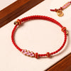 Red braided rope bracelet with pink flower beads and gold knots