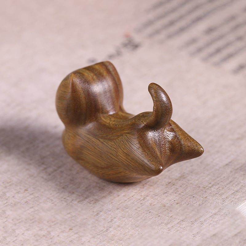 Close up of a green sandalwood incense burner carved into the shape of a sleeping cat.