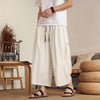Man wearing beige wide leg linen pants with drawstring waist