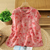 Front view of a pink floral sleeveless top on a wooden hanger