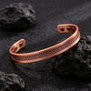 Brushed copper magnetic cuff bracelet with geometric texture on dark rocks