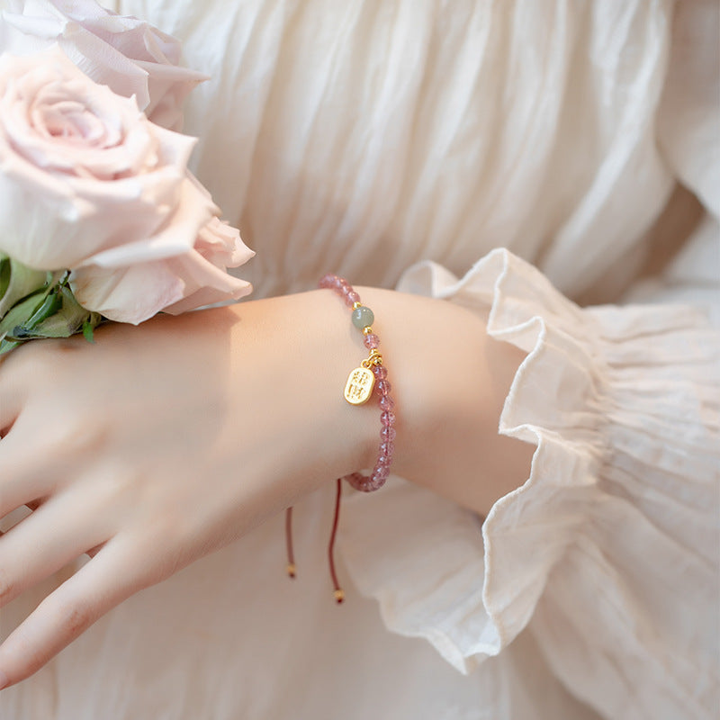 Pink Strawberry Quartz beaded bracelet with gold Fu charm on wrist