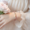 Pink Strawberry Quartz beaded bracelet with gold Fu charm on wrist