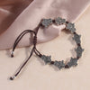 Close up of silver Pixiu beads on a brown woven cord bracelet