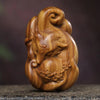Close up view of a carved green sandalwood nine tailed fox figurine resting on a stone surface
