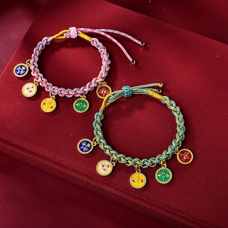 Two multicolored braided bracelets with gold-tone charms on a red background
