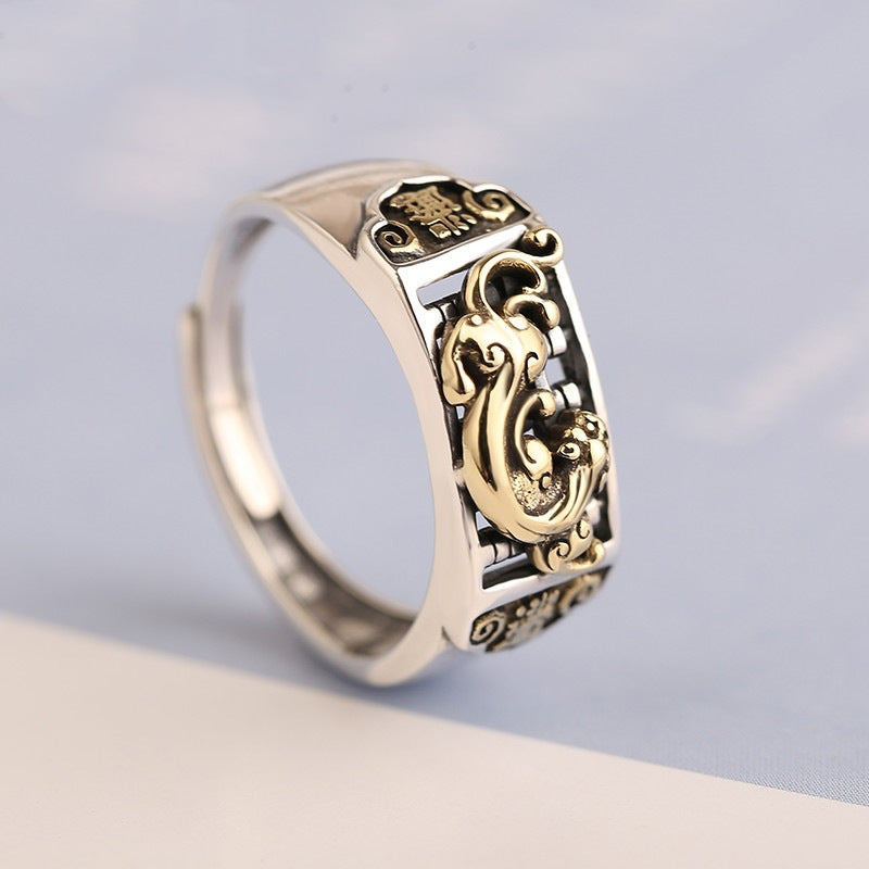 Close-up of a silver adjustable ring with a gold-tone Pixiu figure on the face