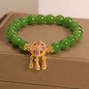 Green crystal bead bracelet with gold tone four leaf clover and dreamcatcher charm