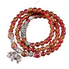 Triple wrap watermelon crystal bracelet with silver elephant charm on wood