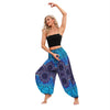 Model wearing loose blue harem pants with a dark compass pattern