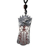 Close-up of a silver plated copper pendant with a Pixiu head and engraved script on a dark background