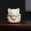 Front view of a white ivory nut carving of a sleeping nine-tailed fox