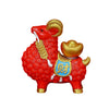 Red resin ram figurine with gold ingot charm on a wooden desk