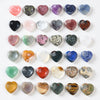 Assortment of colorful heart-shaped natural stone worry stones arranged on a white background