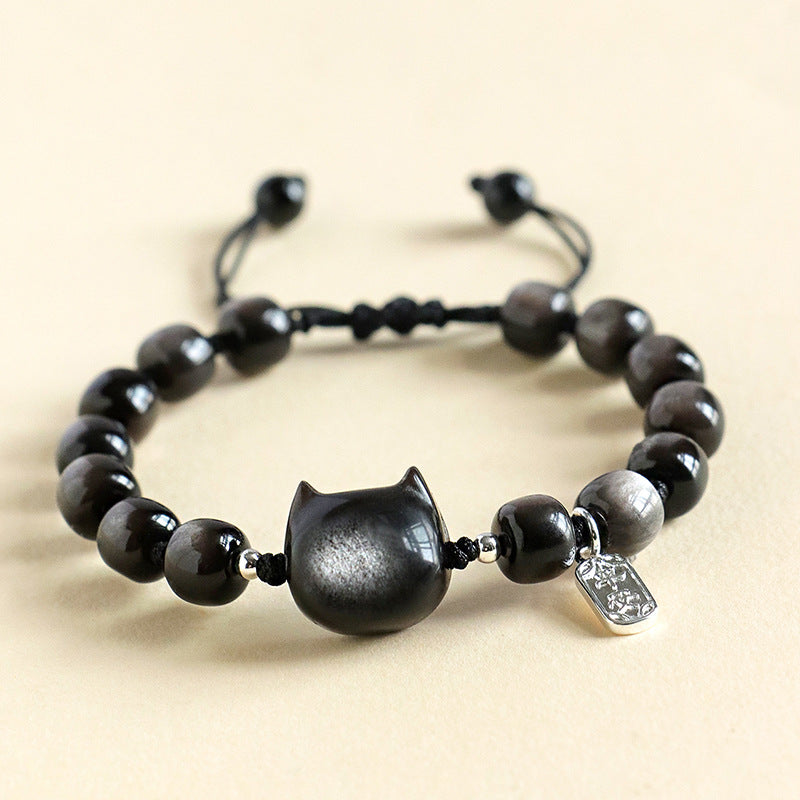 Close up view of square silver sheen obsidian beads on a black cord