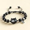 Close up view of square silver sheen obsidian beads on a black cord